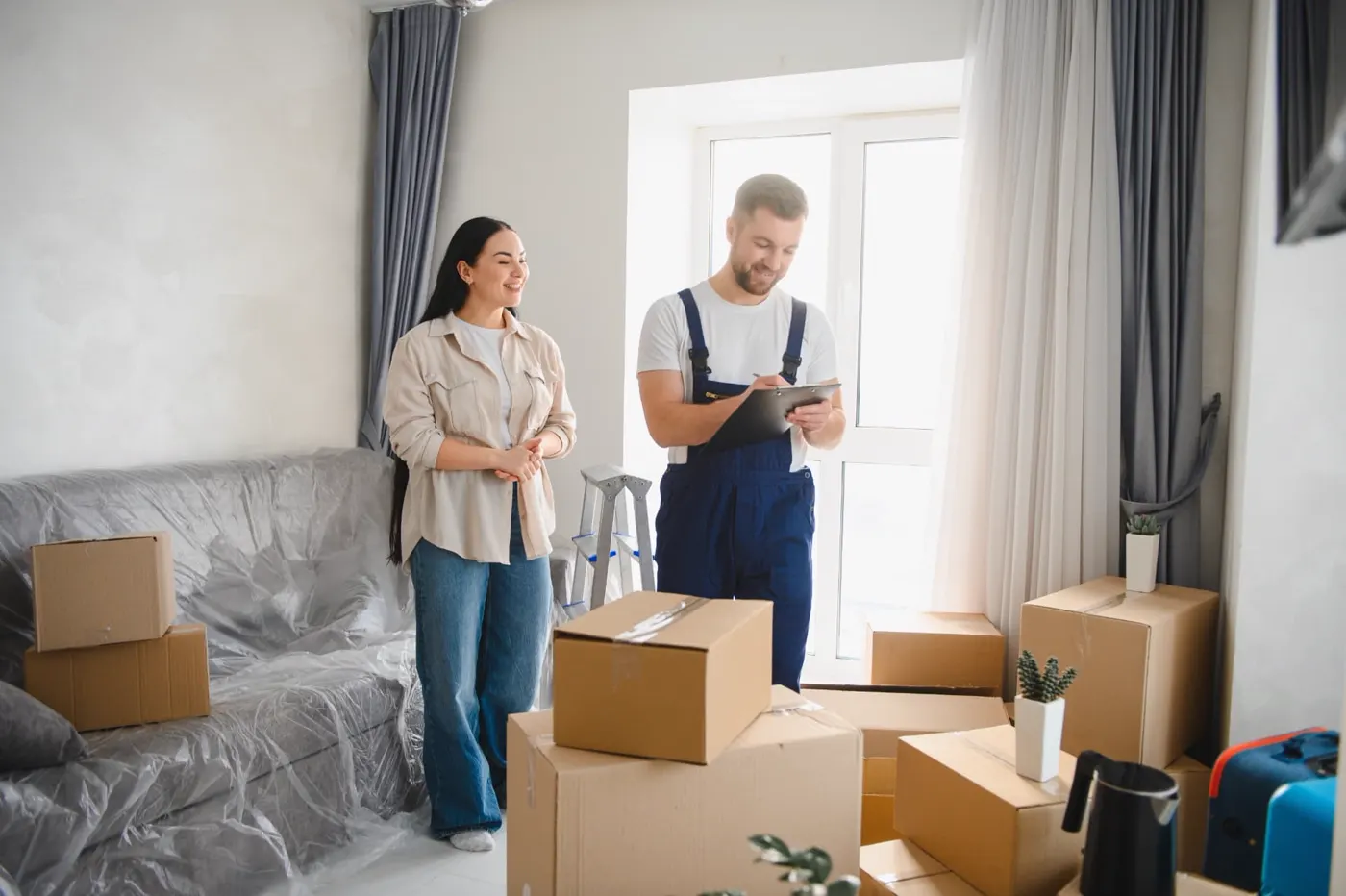 Mover with a clipboard reviewing a move with a customer in a living room